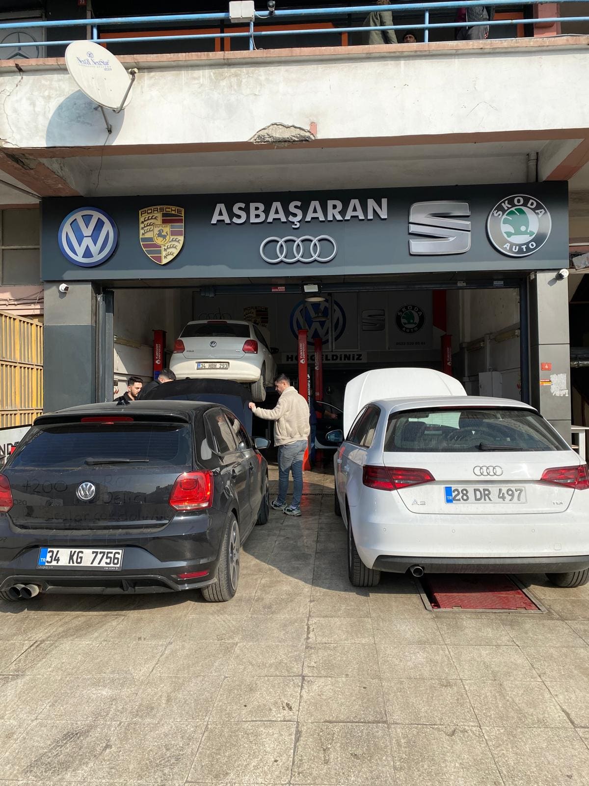 Kartal atölyesinde ustalar giriş alanında araç başında çalışırken